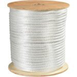 A large spool of MH-USA 1/2, White Solid Braided Nylon Rope with 3,900 lb capacity is neatly wound around a wooden reel, showcasing its resilience and precision.