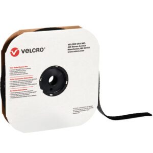 The 1 x 75 Black VELCRO® Brand Tape (Hook, Individual Strips) is partially unwound. The packaging is square and white with a central black reel, displaying the Velcro logo and company details in red and black text.