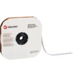 A large roll of 1 3/8 White VELCRO® Brand Tape featuring individual loop dots is partially pulled from its card dispenser, showcasing a central hole and displaying the Velcro logo and contact details.