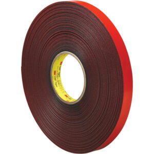 A 3/4 x 5 yds. gray 3M™ 4611 VHB™ Tape roll, with a black exterior and striking red backing, stands upright featuring a yellow core label.