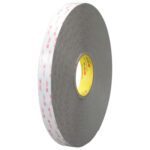 A large roll of 1/2 x 5 yds. White 3M™ 4959 VHB™ Tape features a gray edge and red pattern on the peel-off cover, wound around a yellow core with the iconic 3M logo displayed prominently.