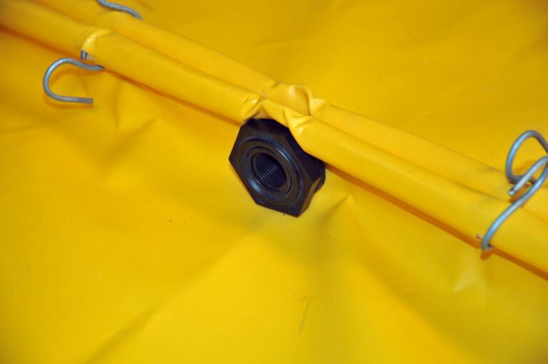 VLPUT-BF_A.jpg Close-up of a black nut securing yellow fabric, resembling the Vestil Bulkhead Fitting Flexible Spill Deck, with metal hooks along its edges.