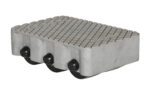 The Vestil Cast Aluminum Dolly 3000 Lb, measuring 12.5L x 8.5W inches, has a textured crosshatch top and three black wheels in a row for easy maneuverability.