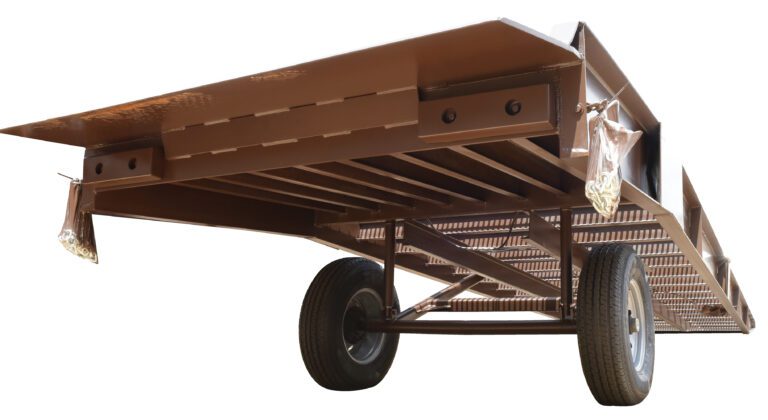 A low-angle view of the Vestil Steel Yard Ramp Overlap Style 30K 85X36 reveals a brown metal trailer with two wheels, a flat platform, and a sturdy underside frame designed for heavy-duty tasks. The matte finish enhances its robust structure, ideal for handling up to 30K.