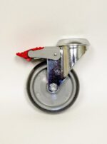 A single swiveling caster wheel with a metal frame and a red brake lever is displayed against a plain white background. Perfect for high-quality laboratory furniture, the wheel is made of gray rubber with a metallic mount and black edges.