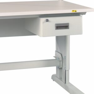 A gray metal workbench with an attached drawer beneath the tabletop. The bench has an adjustable support frame, visible legs, and a small yellow warning label on the corner of the tabletop.