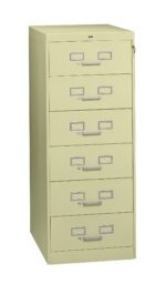 A tall, light green metal filing cabinet with six drawers. Each drawer features a handle and a label holder. The cabinet has a lock at the top right corner. It stands on a plain white background.
