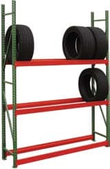 A metal storage rack with an innovative design boasts three red shelves holding four large black tires. Two rest on the top, while the middle shelf supports the others. Enhancing storage efficiency, its green vertical supports ensure stability and style, leaving the bottom shelf empty for future needs.