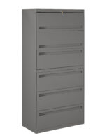 A tall, grey metal filing cabinet with five drawers, each equipped with handles. The top drawer has a visible lock with a key. The cabinet stands alone against a plain white background.