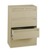 A beige metal filing cabinet with three drawers is shown. The top two drawers are closed, and the bottom drawer is partially open, revealing its depth. The cabinet has a lock on the top drawer.