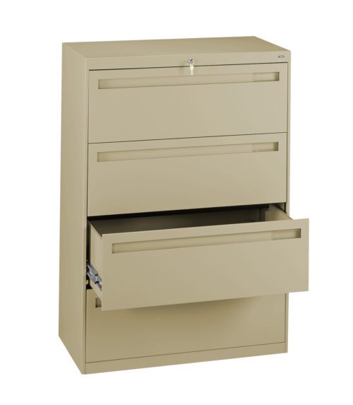 A beige metal filing cabinet with three drawers is shown. The top two drawers are closed, and the bottom drawer is partially open, revealing its depth. The cabinet has a lock on the top drawer.
