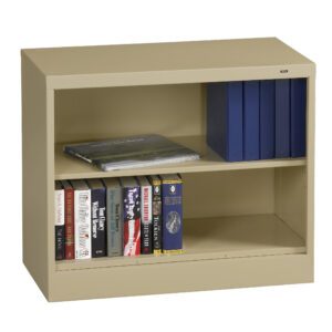 A beige metal bookshelf with two shelves. The top shelf has blue binders and a book lying flat. The bottom shelf contains various books lined up vertically. The bookshelf is set against a white background.