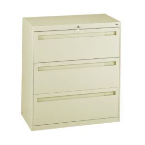 A beige, three-drawer lateral filing cabinet with a lock on the top drawer. The drawers have recessed handles for opening. The cabinet is standing on a flat surface against a white background.