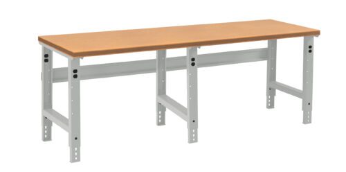mu0fldf37q52tst3vcmk.jpg A long, rectangular workbench with a light brown wooden top and adjustable metallic legs. The legs are gray and have multiple holes for height adjustment. The bench is set against a plain white background.
