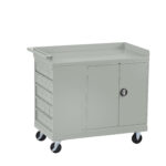 Gray metal utility cart with lockable doors and multiple drawers on the left side. It has a flat top surface and four wheels for mobility. The design is simple and functional, suitable for storage and transport of tools or supplies.