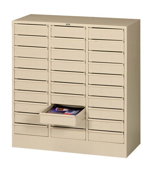 A beige, multi-drawer storage cabinet with a grid of small square drawers. One drawer is open, revealing some colorful items inside. The cabinet is set against a plain, white background.
