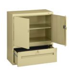 A beige metal storage cabinet with two open doors revealing two shelves inside. Below, there is an open drawer. The cabinet has a simple, industrial design and a keyhole on one door for locking.