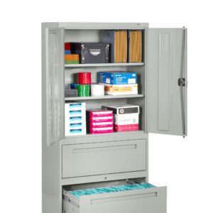 A gray metal cabinet with five shelves. The top holds boxes and small containers. Middle shelves contain office supplies like envelopes and paper packs. The bottom shelves have two drawers, one open with hanging folders inside.