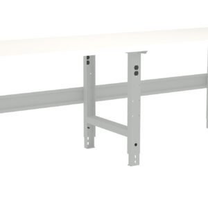 A long, white workbench with adjustable metal legs. The bench has a simple, sturdy design, suitable for various tasks in a workshop or garage setting.