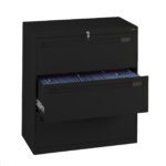 A black filing cabinet with three drawers, one of which is open and filled with hanging file folders. The top drawer has a visible key lock with a key inserted. The cabinet is positioned against a white background.