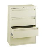 A beige metal filing cabinet with three drawers. The top two drawers are closed, and the bottom drawer is partially open, revealing its storage space. The cabinet has a sleek, modern design and a lock at the top.