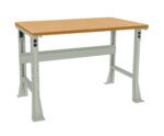 A sturdy workbench with a light wooden top and metal frame. The legs are adjustable, featuring multiple holes for height customization. The design is simple and functional, suited for industrial or workshop environments.