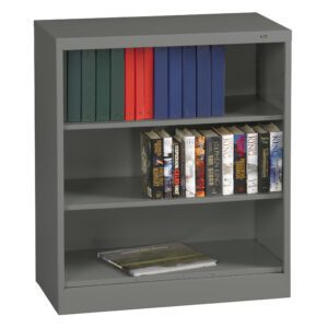 A gray metal bookshelf with three shelves. The top shelf has blue and red binders, the middle shelf displays various Stephen King novels, and the bottom shelf has a closed book.