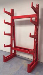 A red, metal cantilever rack with five horizontal arms on each side, designed for storing long, bulky items. It is positioned against a blank wall on a blue floor.