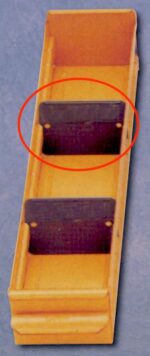 A long, rectangular yellow plastic tray with two black dividers inside. A red circle highlights the dividers. The tray has raised edges and a textured surface, resting on a gray background.