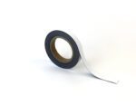 Set against a plain white background is a roll of black adhesive tape with a white backing, partially unrolled, reminiscent of the simple and efficient MH-USA Magnetic Easy-Wipe Strip, White, measuring H.0.79 in. x W3.94 in.