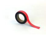 A roll of MH-USA Magnetic Easy-Wipe Strip - Red - H.1.18 in. x W3.94 in. adhesive tape is partially unrolled on a white background, with its end extending right, showcasing the black inner rim.