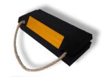 The TCT Military Wheel Chock features double-sided black construction, a yellow reflective strip for visibility, and a rope handle. Dimensions: 14x5.5x3.5.