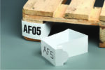 A wooden pallet with an AF05 tag is attached to a corner, while a similar loose MH-USA Pallet Marker - White - H.2.95 in. x W.18.5 in., Pack of 50, labeled AF5, rests on the gray floor nearby.
