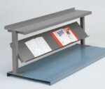 A gray metal bookstand with an angled shelf holding two open books. The stand has a flat top, sturdy legs, and is set on a blue base. The books appear to contain diagrams and illustrations.