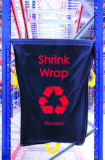 The MH-USA Racksack - Shrink Wrap, in black, features a red recycling symbol and is attached to a metal frame. Clearly branded as racksack, it stands out in a well-lit industrial setting for efficient and visible recycling.