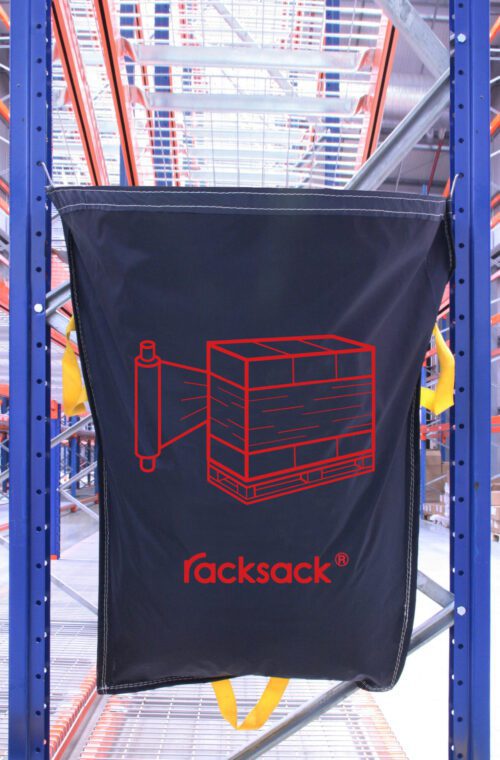 A black sack labeled MH-USA Racksack Symbol Only - Shrink Wrap featuring a red shrink wrap icon on a pallet hangs between metal shelves in a warehouse.