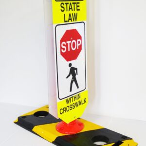 The TCT Flexible Post Crosswalk System features a yellow and black sign with School State Law - Stop Within Crosswalk, including a red stop sign graphic over a walking figure, mounted on a robust black and yellow base.
