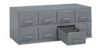 A gray metal organizer with eight small drawers. One drawer is partially open, revealing a small compartment. The organizer has a simple, industrial design.