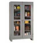 A gray storage cabinet with two glass-paneled doors. Inside, shelves hold various tools and supplies, including rolls of tape, spray cans, a yellow hard hat, and small boxes. The cabinet is set against a plain background.