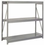 A large gray industrial shelving unit with three metal shelves and a sturdy frame. The design features perforated edges and cross-bracing for stability. The shelves are adjustable and suitable for heavy storage.