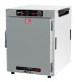 The image shows a Metro HBCW8-AS-CT HotBlox, a silver-colored 120V, 875W warming cabinet with NEMA 5-15P plug. It has black side handles, an analog controller with knobs, a temperature gauge, and a front door with handle. Its ideal for keeping food warm.
