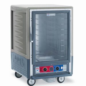 The Metro C535-CFC-4-GY C5 3 Series Insulated Holding/Proofing Cabinet, with a gray textured exterior and full-length clear door, includes fixed wire slides and four wheels for mobility. It features a bottom control panel with dials, optimized for commercial use.