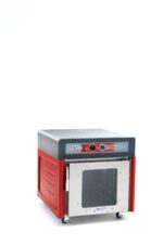 The Metro C543X-ASFC-U Insulated Holding Cabinet in red and gray has a full-length clear door, control knobs, operates at 220-240V, and is mounted on wheels for mobility. It is set against a plain white background.
