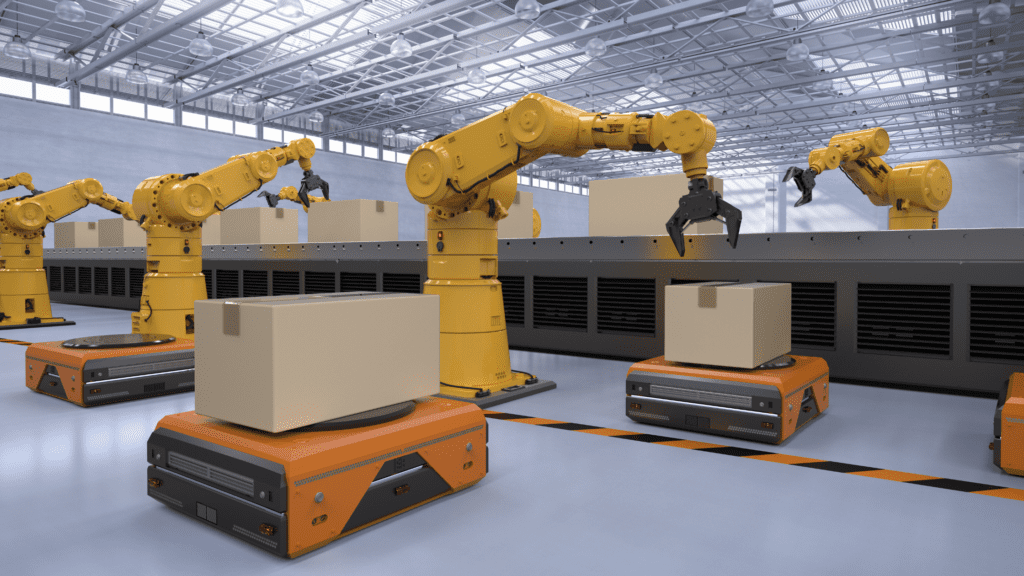 Robotic arms with yellow joints efficiently position large cardboard boxes onto orange platforms in a modern, well-lit warehouse. These platforms, part of an automated storage system, glide along a conveyor beneath a high ceiling illuminated by a grid of lights.