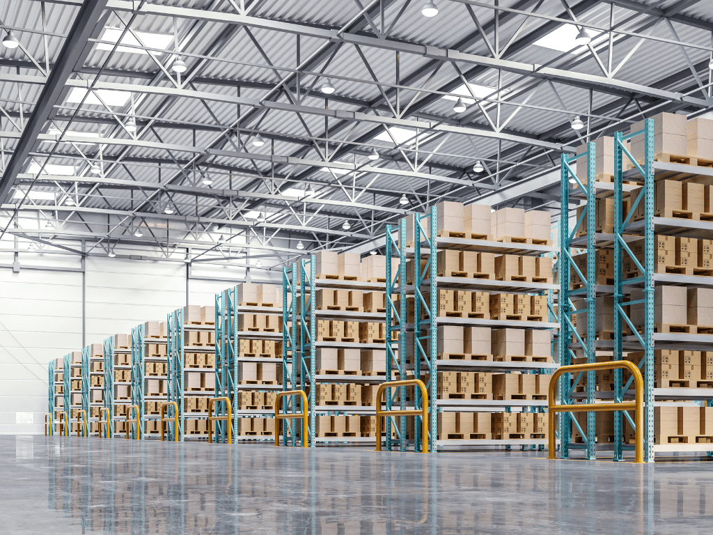 Spacious warehouse interior with high ceilings and industrial lighting awaits. Tall metal racks, perfect for improving your bottom line, are filled with neatly stacked boxes on the polished concrete floor. The well-organized scene is brightly lit, ready to transform your storage space.
