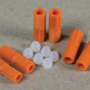 The Justrite 2.5 mm Tubing Connector Set features orange plastic dowels with ridges and small, white cone-shaped hollow caps, arranged on a textured beige surface.