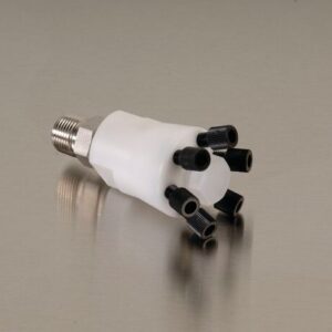 A white cylindrical Justrite Manifold, Poly W/Ss Stacker, with a metallic threaded end and six black nozzles on the other side, rests elegantly on a smooth surface.