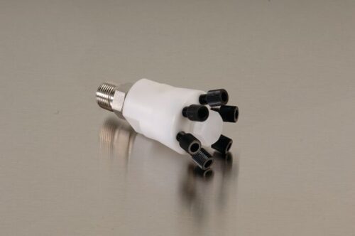 A white cylindrical Justrite Manifold, Poly W/Ss Stacker, with a metallic threaded end and six black nozzles on the other side, rests elegantly on a smooth surface.