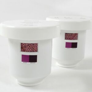 The Justrite Filter, Clr Crtrdg, 2Pk, Aerslv features two white cylindrical containers with small windows displaying pink beads inside. Each container has READY and REPLACE indicators in matching pink on a pristine white background.