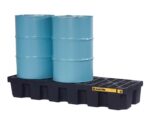 Two blue industrial barrels rest on a robust Justrite Pallet, 3 Drum, Ecopoly, Blk with a grated surface and a yellow label. The setup is displayed against a pristine white background.